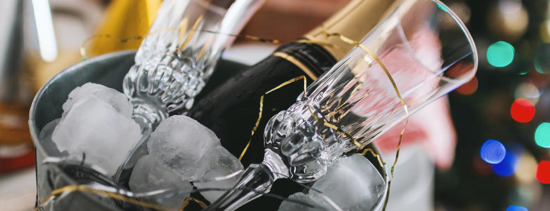 Cubo con botella de champán, hielo y dos copas